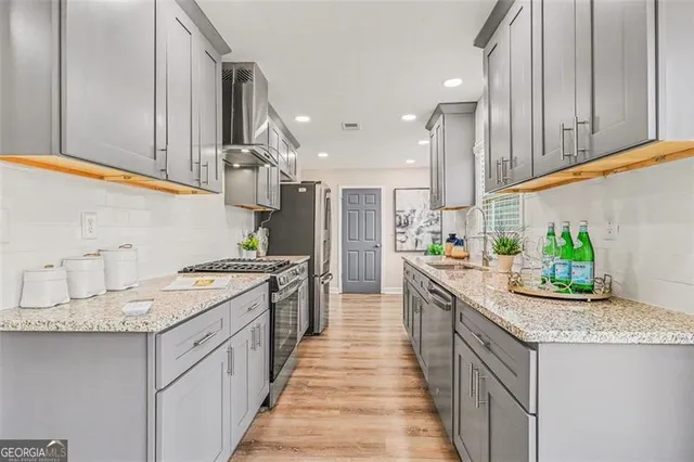 a kitchen with stainless steel appliances granite countertop a sink and stove