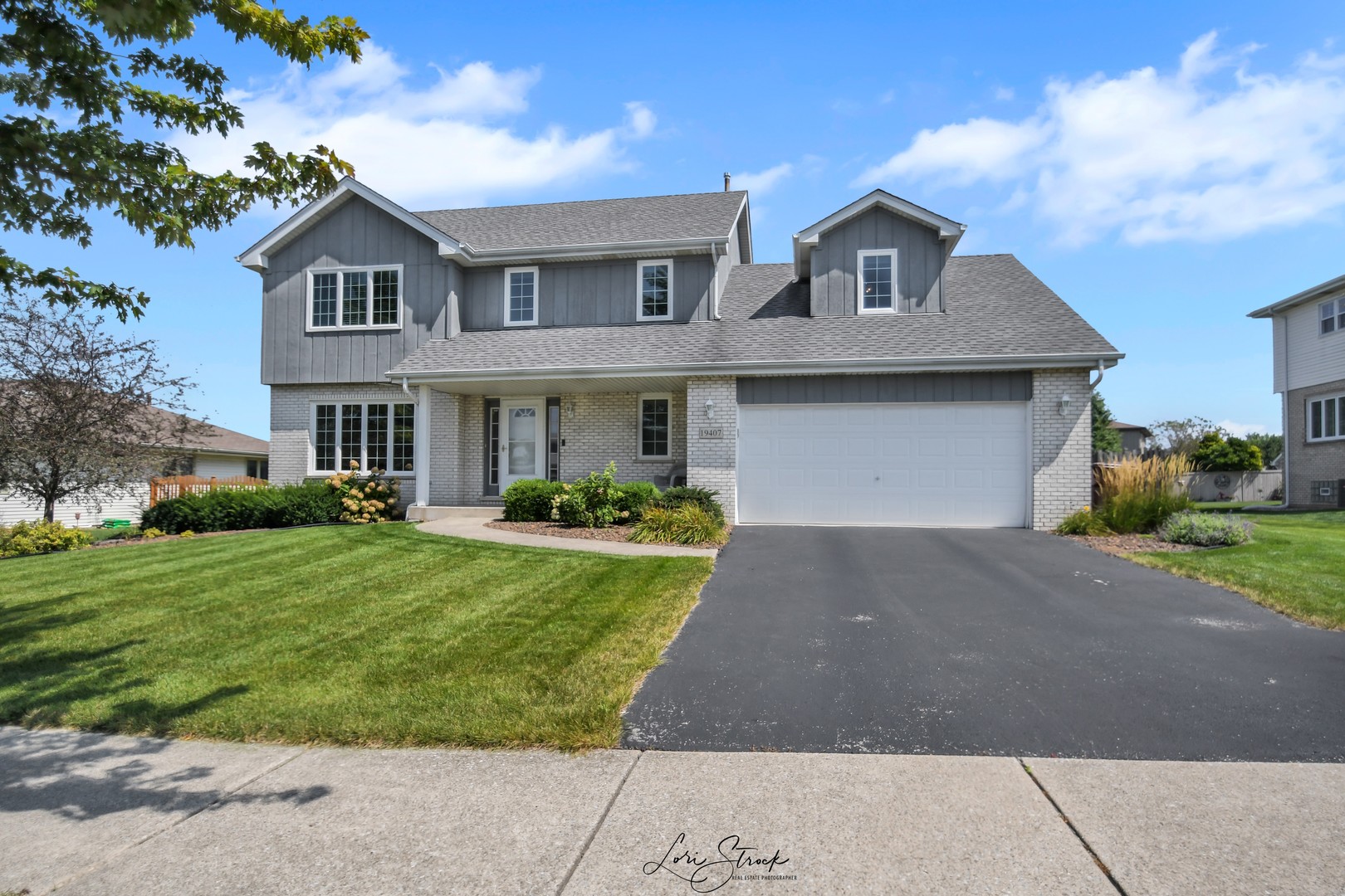 a front view of a house with a yard and garage