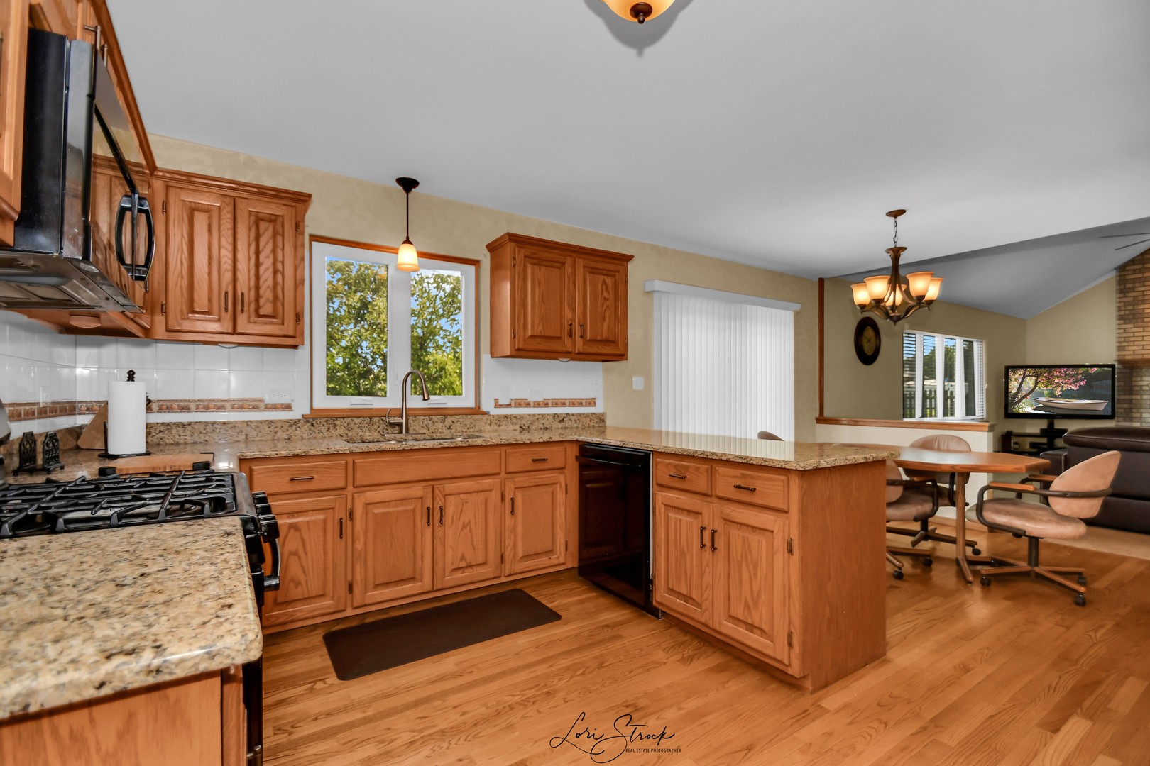 19407 Cherry Street Mokena, IL 60448 - Photo 14 of 33 a kitchen with stainless steel appliances granite countertop a stove a sink dishwasher and white cabinets with wooden floor