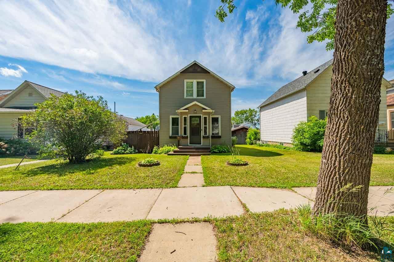 508 10th Street South Virginia, MN 55792 - Photo 41 of 43 Traditional two-story home featuring a light gray exterior, white trim, and a prominent front porch with a dark entry door