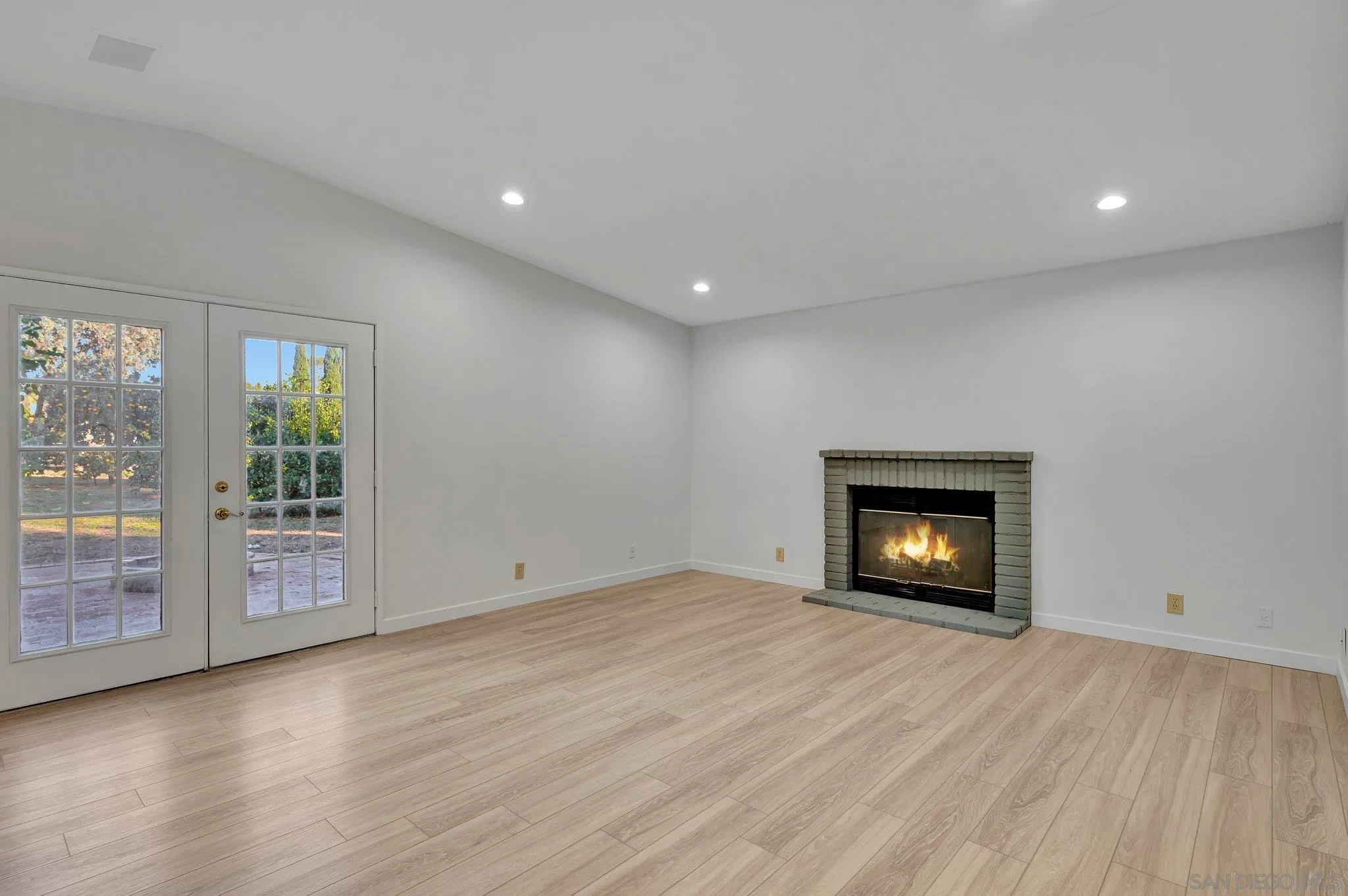 13455 Olive Tree Lane Poway, CA 92064 - Photo 12 of 36 a view of an empty room with wooden floor and a fireplace