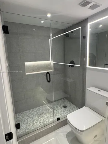 a bathroom with a toilet and a shower