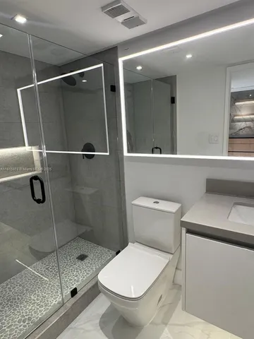 a bathroom with a sink a toilet and mirror