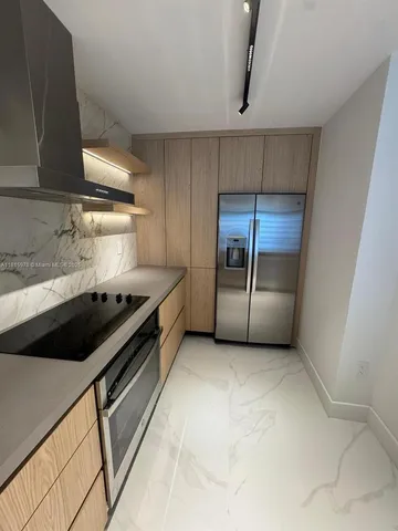 a kitchen with granite countertop a stove and a refrigerator