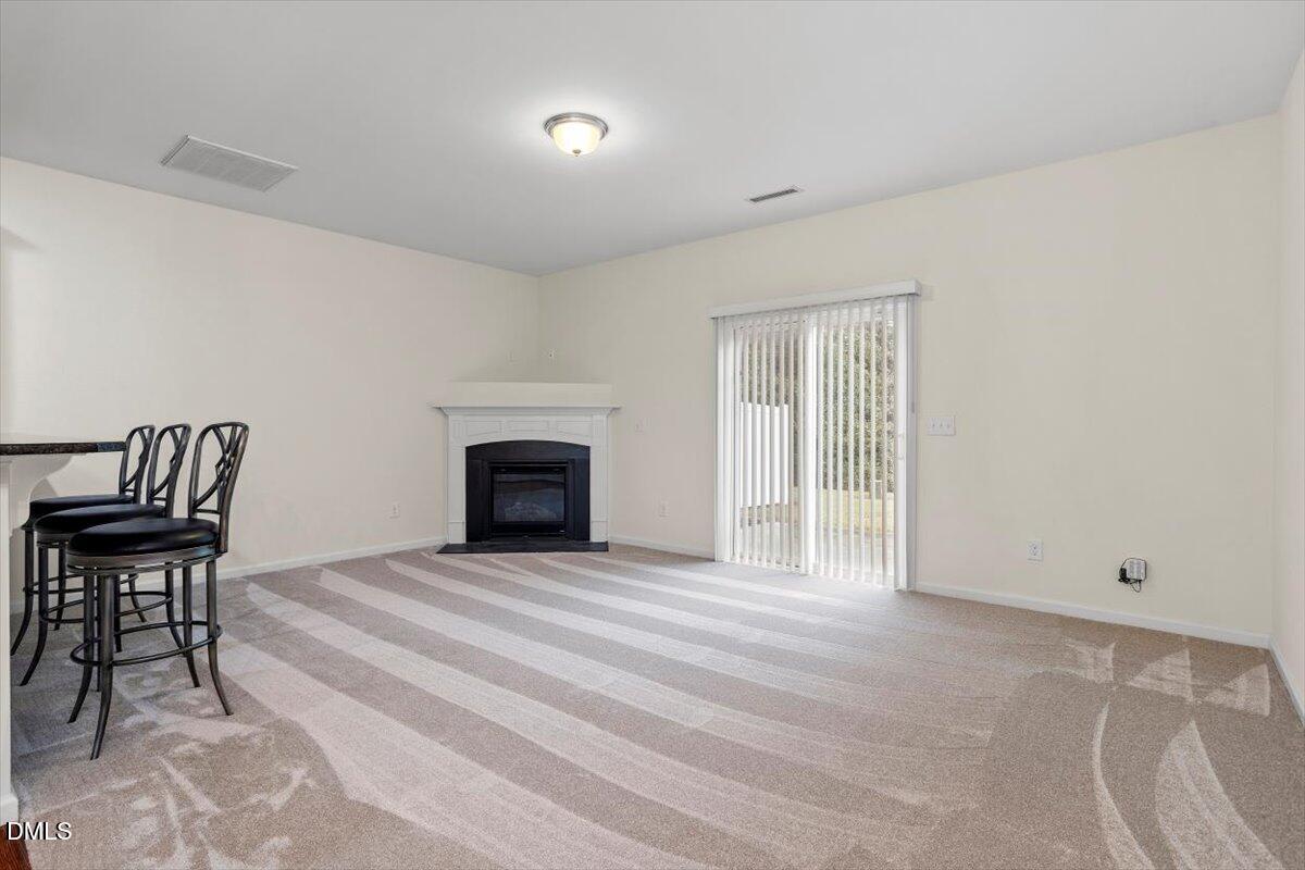 2306 Stoney Spring Drive Raleigh, NC 27610 - Photo 13 of 36 a view of an empty room with a fireplace and a window