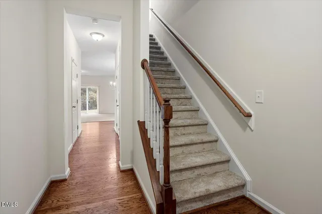 a kitchen with stainless steel appliances granite countertop a refrigerator a stove and a sink with wooden floor