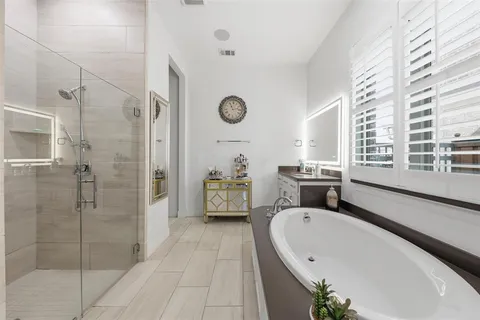 a bathroom with a granite countertop tub sink a mirror and a shower