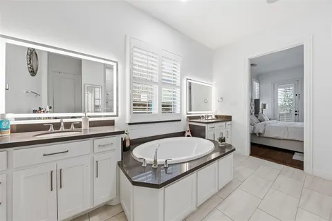a bathroom with a tub sink and mirror
