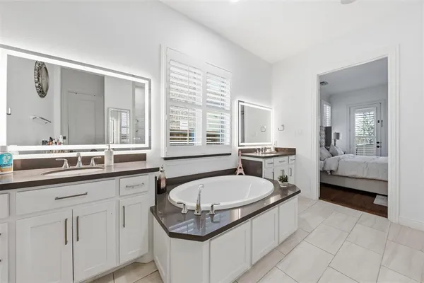 a bathroom with a tub sink and mirror