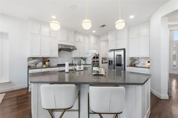 a kitchen with kitchen island a counter top space cabinets and stainless steel appliances