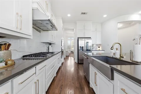 a large kitchen with stainless steel appliances granite countertop a lot of counter space and wooden floors