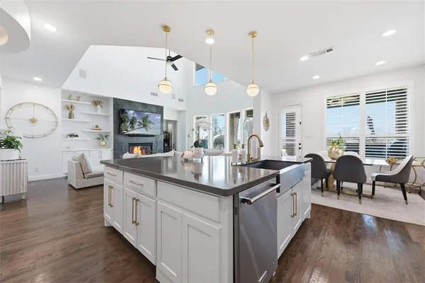 a kitchen with counter top space a sink appliances and wooden floor