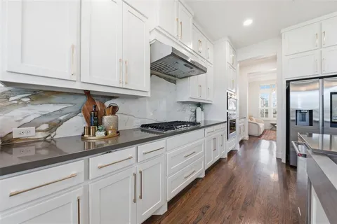 a kitchen with stainless steel appliances granite countertop a lot of counter space and wooden floors