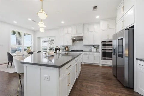 a kitchen with counter top space a sink stainless steel appliances and cabinets