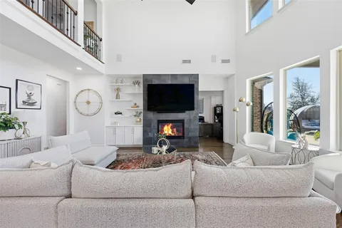 a living room with furniture a fireplace and a large window