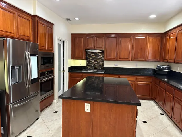 a kitchen with stainless steel appliances granite countertop a refrigerator and a sink