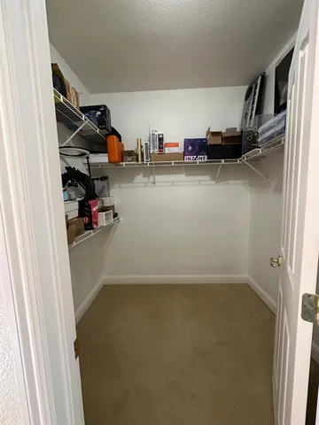 a view of walk in closet with clothes and shoes