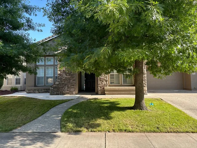 a front view of a house with a yard garage and outdoor seating