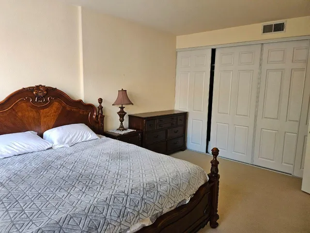a bed sitting in a spacious bedroom next to a window