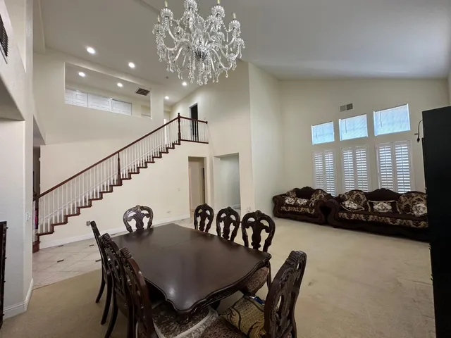 a view of a dining room with furniture and chandelier
