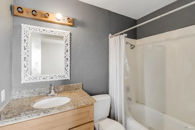 a view of an empty room with a window and a ceiling fan
