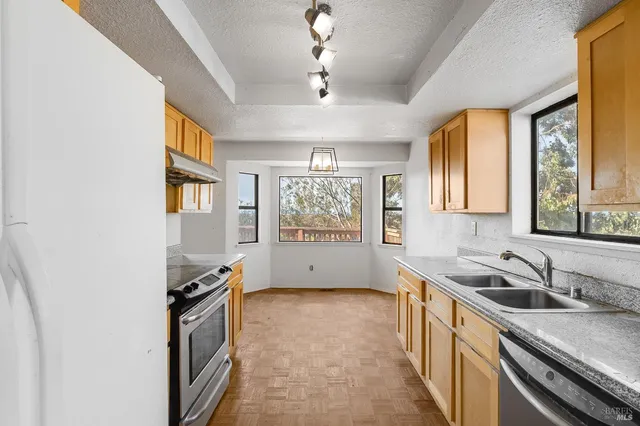 a kitchen with stainless steel appliances granite countertop a stove and a refrigerator