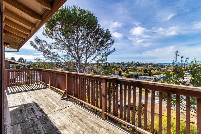 a view of balcony with wooden floor and fence