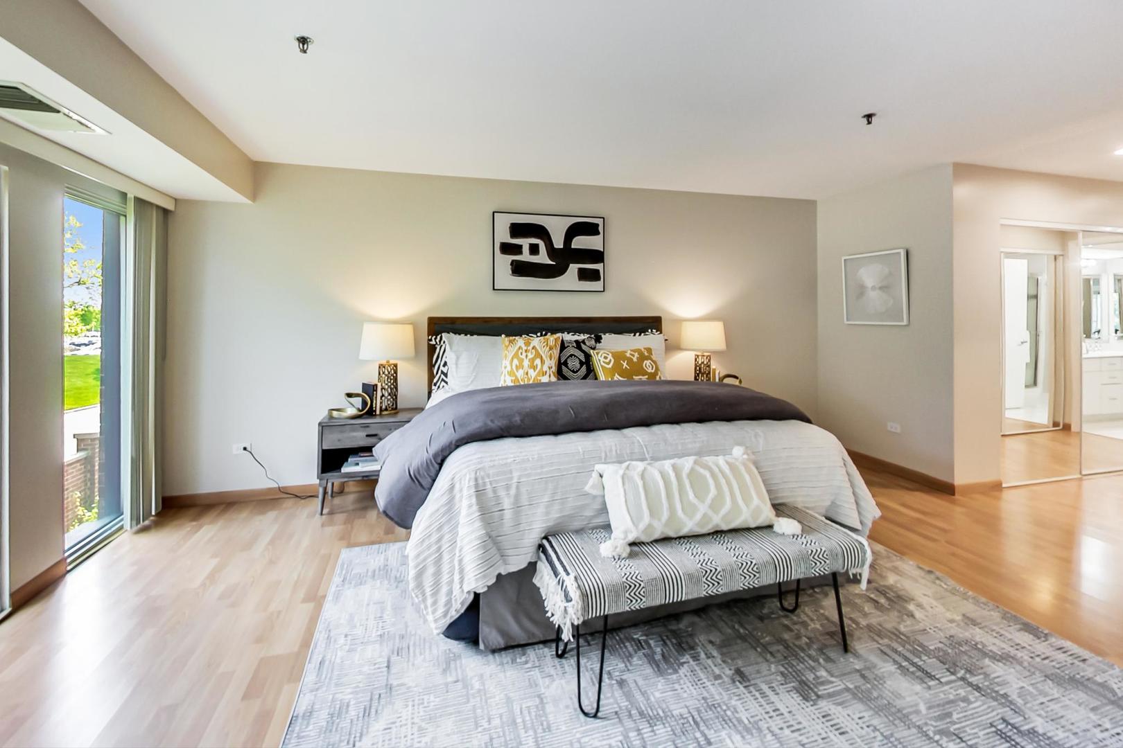 351 Kelburn Road, Unit 213 Deerfield, IL 60015 - Photo 11 of 37 a bedroom with a bed and a lamp on table