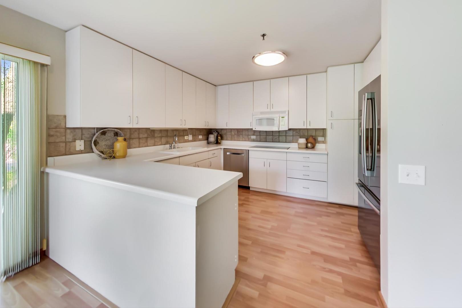 351 Kelburn Road, Unit 213 Deerfield, IL 60015 - Photo 7 of 37 a kitchen with a sink a stove a refrigerator and white cabinets