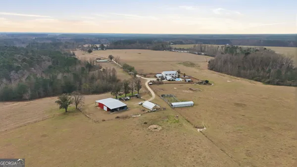 an aerial view of a house with a yard and mountain view in back