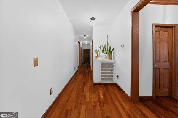 a view of entryway and hall with wooden floor