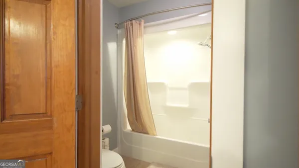 a kitchen with stainless steel appliances kitchen island granite countertop a refrigerator a stove a sink a dining table and chairs with wooden floor