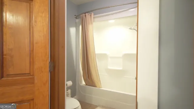 a kitchen with stainless steel appliances kitchen island granite countertop a refrigerator a stove a sink a dining table and chairs with wooden floor