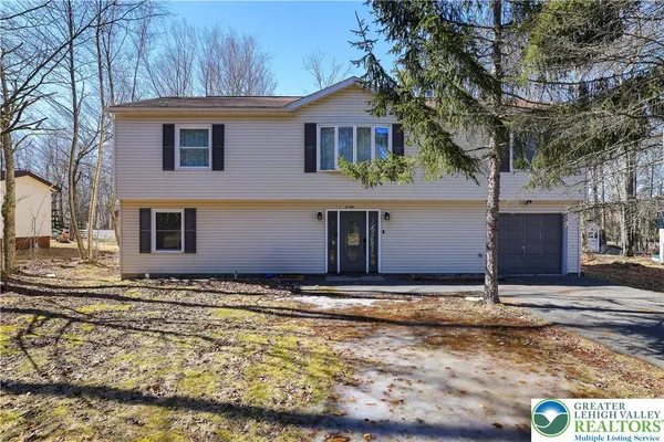 a view of a house with street next to a road