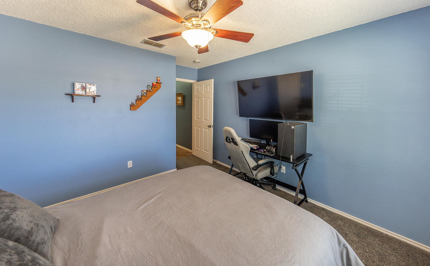 6901 9th Street Lubbock, TX 79416 - Photo 16 of 27 a bedroom with a bed and a flat screen tv