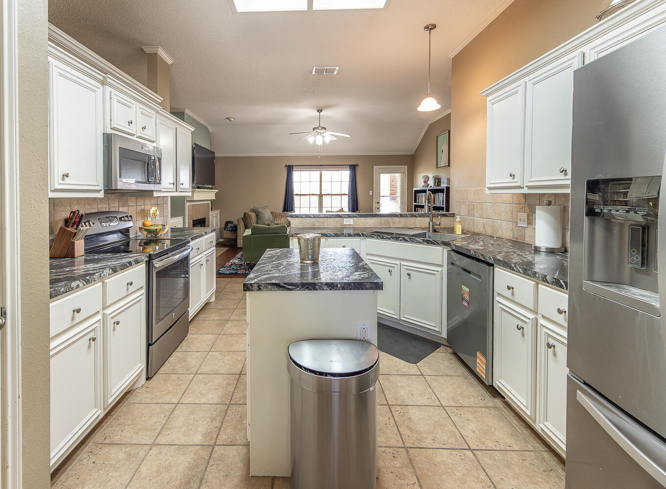 6901 9th Street Lubbock, TX 79416 - Photo 19 of 27 a large kitchen with stainless steel appliances lots of counter space and wooden floor