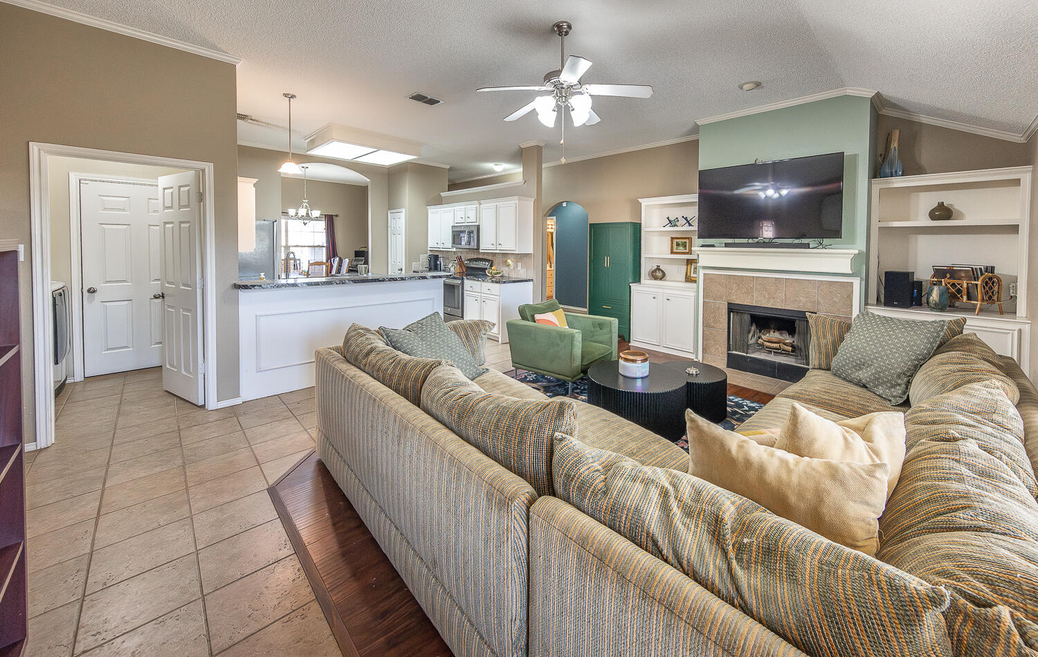 6901 9th Street Lubbock, TX 79416 - Photo 4 of 27 a living room with furniture a fireplace and a flat screen tv