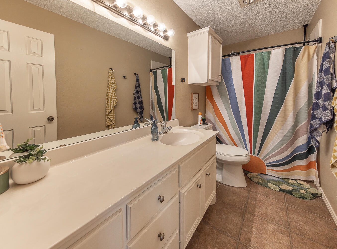 6901 9th Street Lubbock, TX 79416 - Photo 8 of 27 a bathroom with a sink a toilet and a mirror