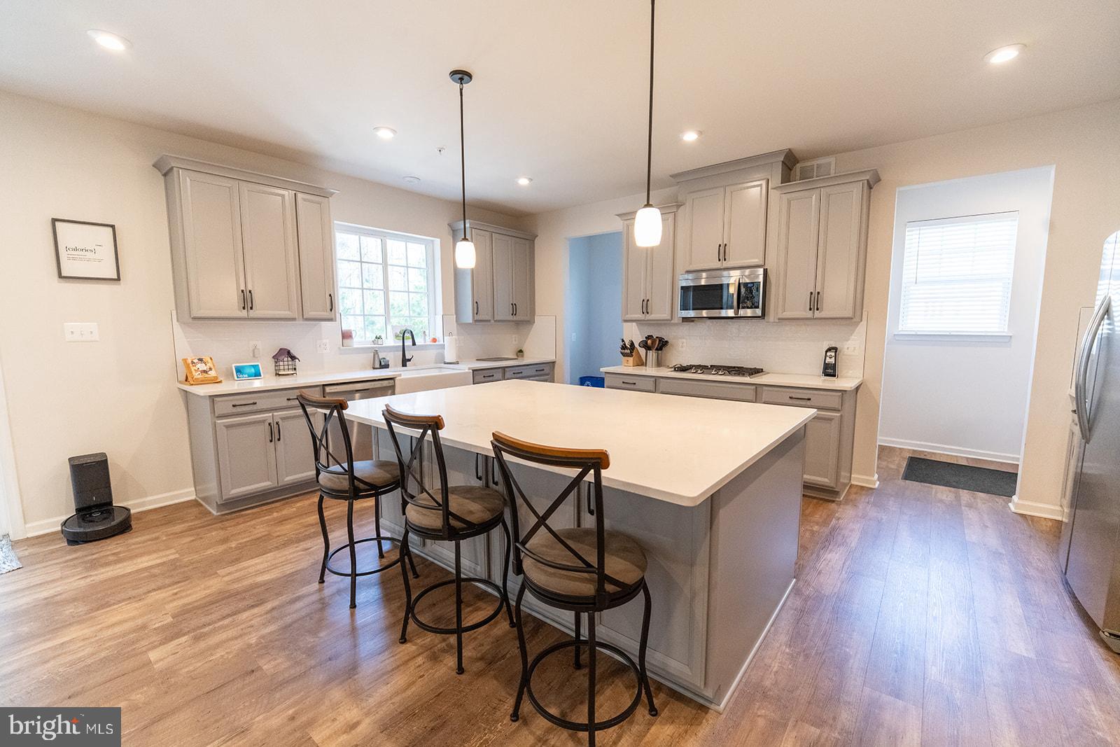 43907 Monterey Street California, MD 20619 - Photo 34 of 95 a kitchen with stainless steel appliances a dining table chairs sink and cabinets