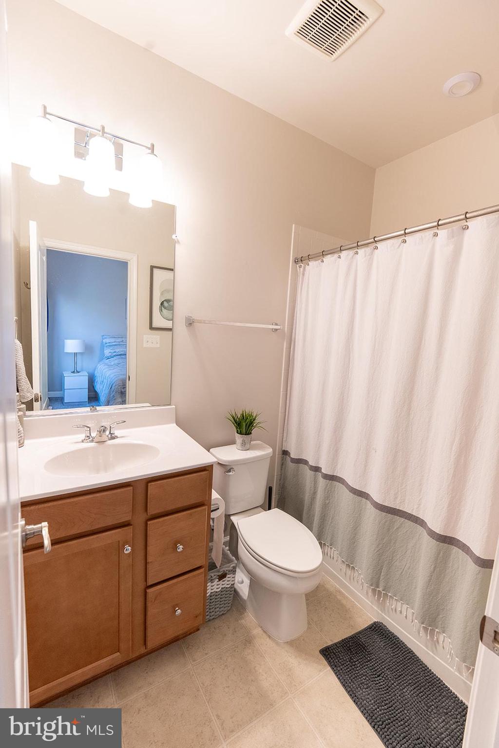 43907 Monterey Street California, MD 20619 - Photo 41 of 95 a bathroom with a sink a toilet a mirror and shower curtain