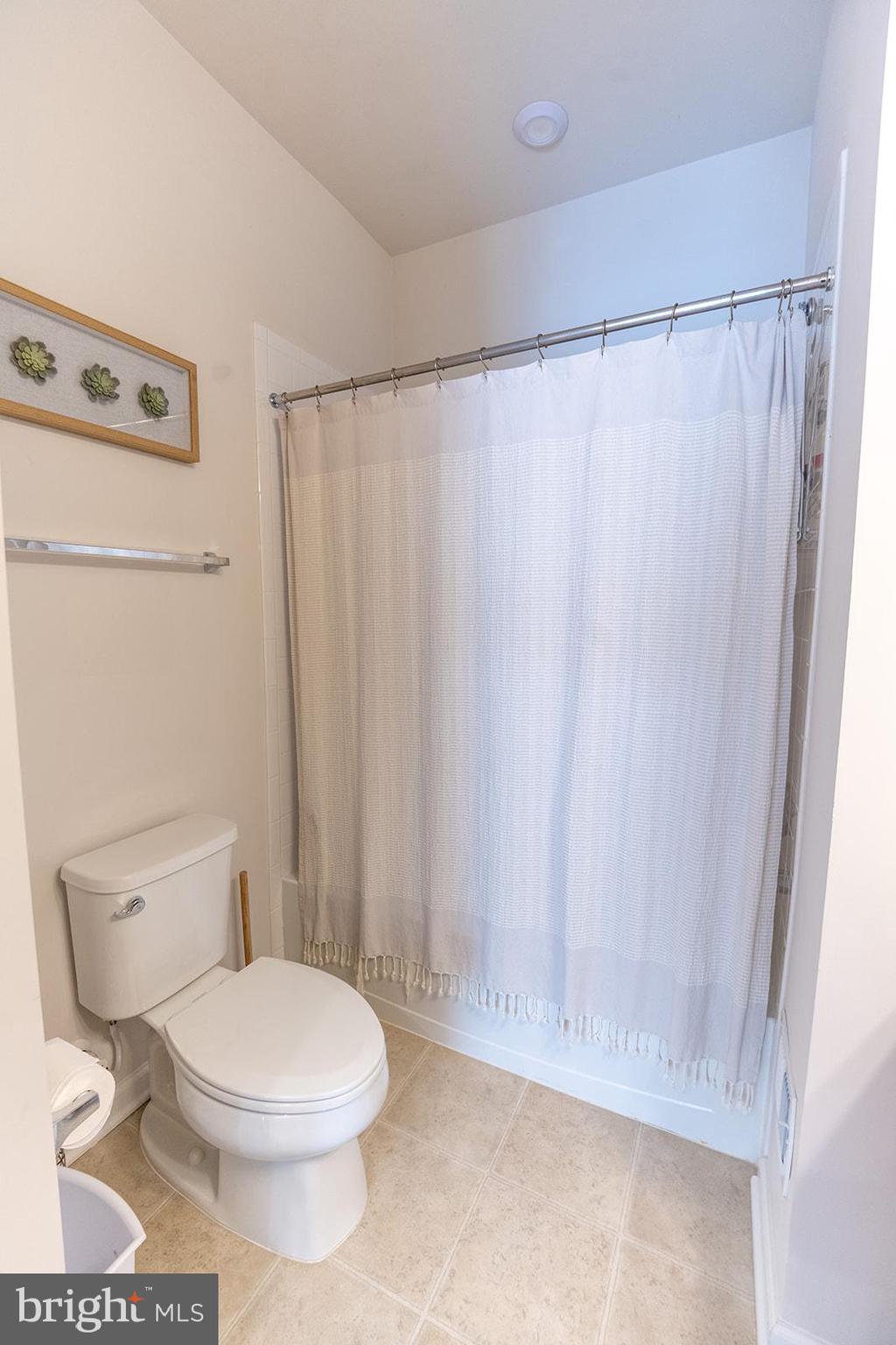 43907 Monterey Street California, MD 20619 - Photo 46 of 95 a white toilet sitting next to a shower curtain