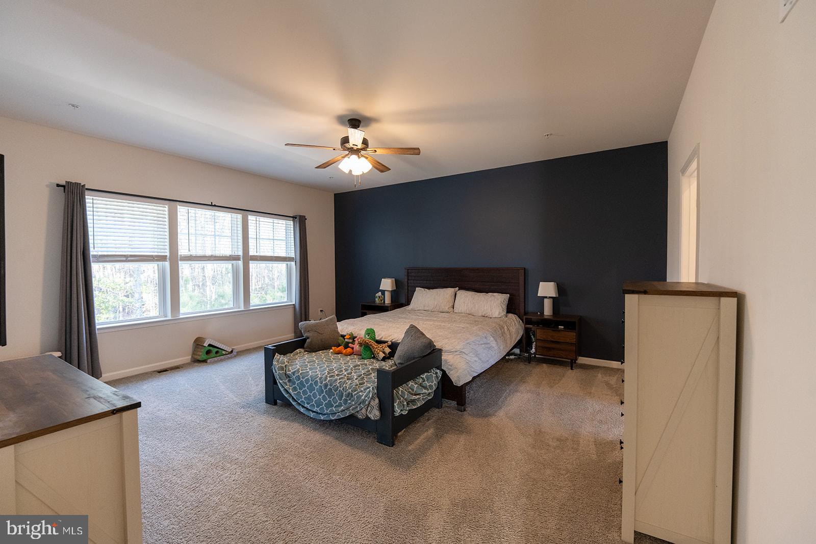 43907 Monterey Street California, MD 20619 - Photo 54 of 95 a spacious bedroom with a bed and a chandelier