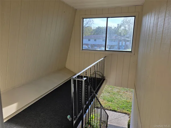 a view of a hallway with wooden floor and stairs