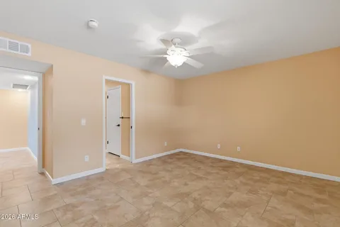 an empty room with a ceiling fan and a window