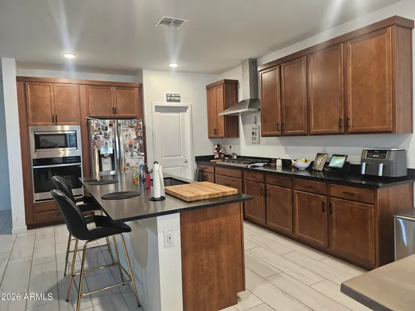 a kitchen with stainless steel appliances granite countertop a stove refrigerator sink and cabinets