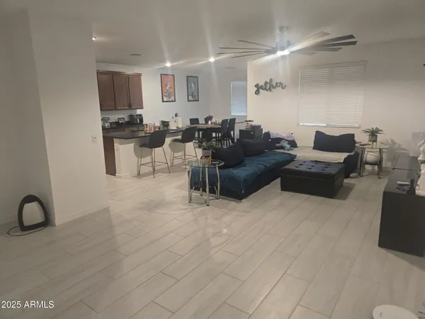 a living room with furniture and a view of kitchen