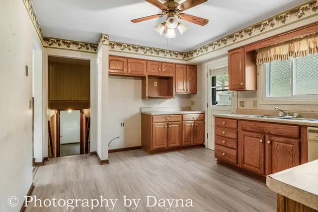 a kitchen with stainless steel appliances a sink cabinets and wooden floor
