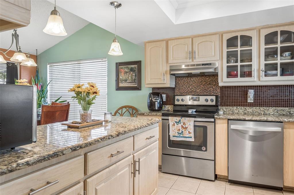 502 Avocado Circle Brandon, FL 33510 - Photo 15 of 50 a kitchen with stainless steel appliances granite countertop a sink a stove and a wooden cabinets