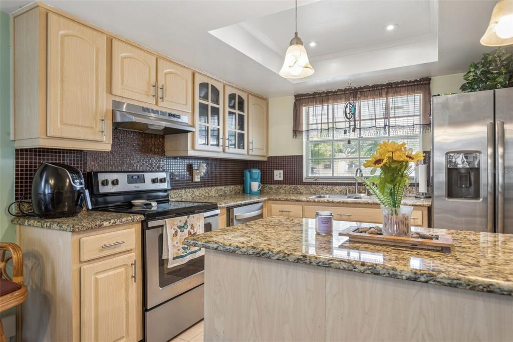 502 Avocado Circle Brandon, FL 33510 - Photo 17 of 50 a kitchen with stainless steel appliances granite countertop a sink a stove cabinets counter space and a window
