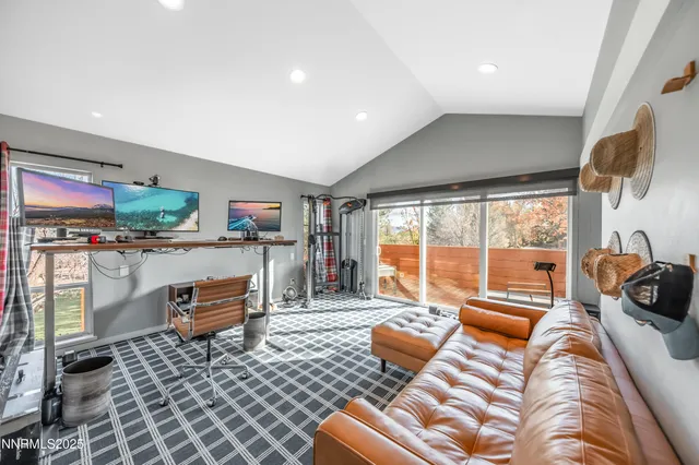 a living room with furniture a flat screen tv and floor to ceiling window